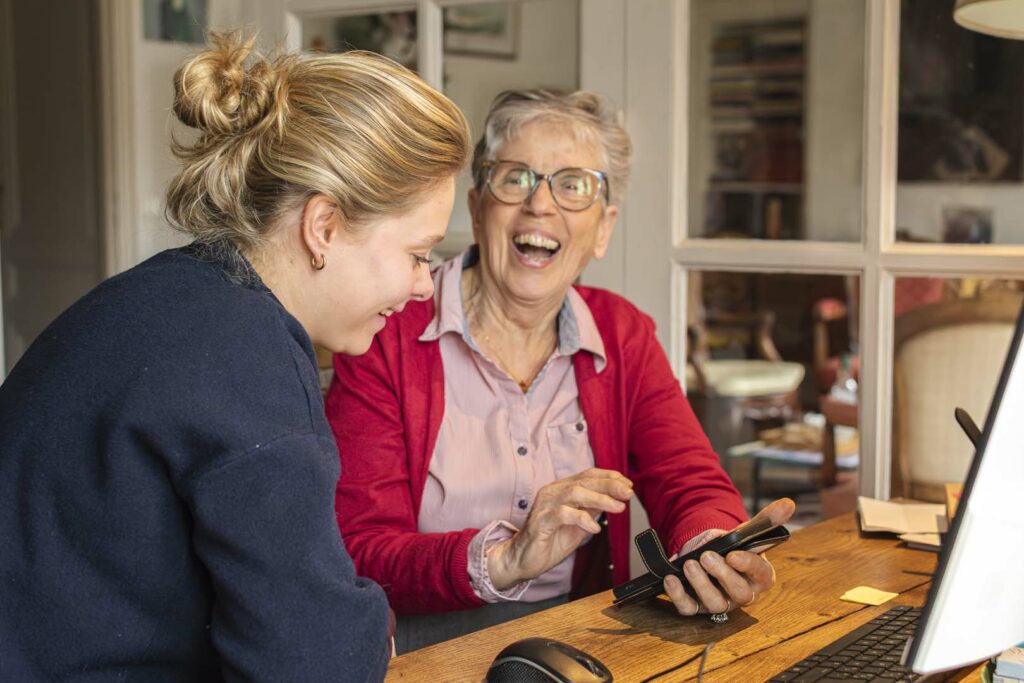Jeune aidant une senior sur son ordinateur Tim&Colette
